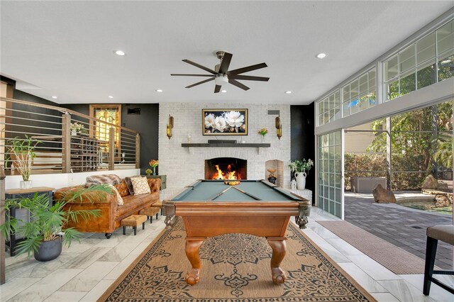 playroom featuring billiards, recessed lighting, a fireplace, a wall of windows, and ceiling fan