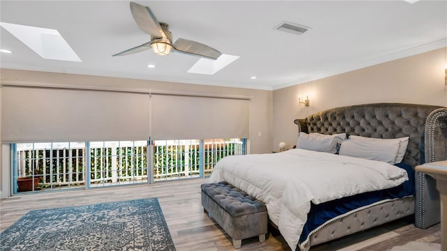 bedroom with visible vents, a skylight, wood finished floors, and ornamental molding