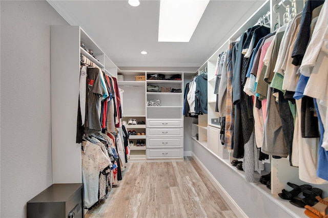 walk in closet featuring light wood-style floors and a skylight