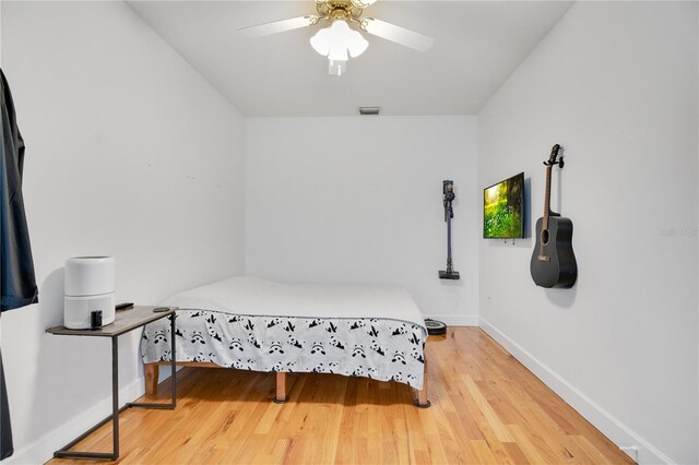 bedroom featuring wood finished floors, baseboards, and ceiling fan