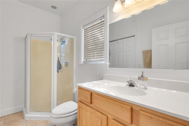 bathroom featuring tile patterned floors, toilet, a stall shower, and vanity