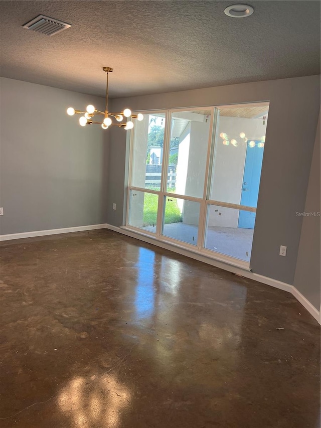 empty room with a textured ceiling and a notable chandelier