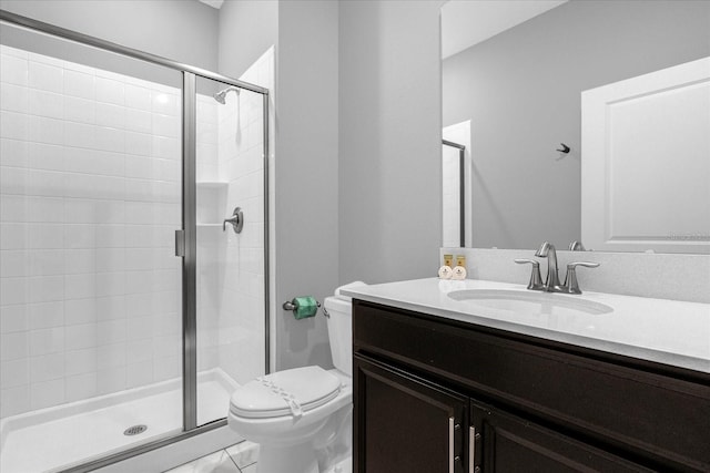 bathroom with vanity, toilet, tile patterned floors, and a shower with shower door