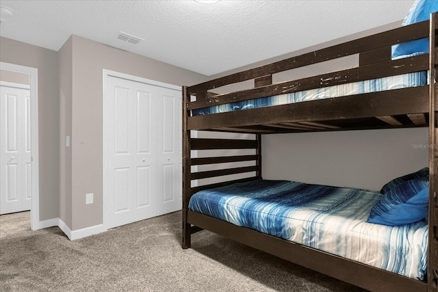 bedroom featuring a closet, a textured ceiling, and carpet floors