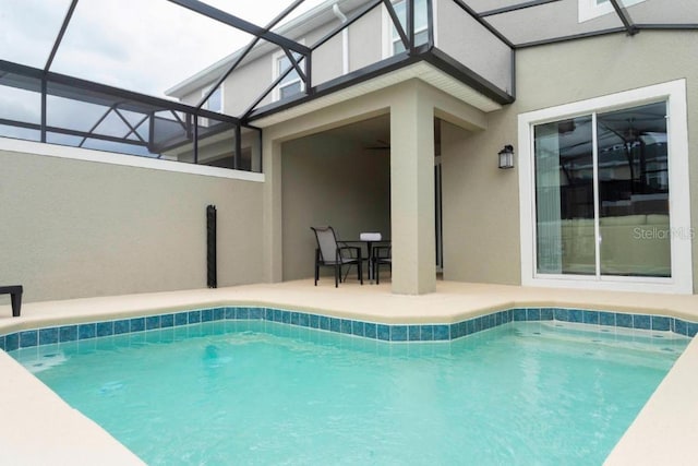 view of swimming pool featuring a patio area, ceiling fan, and a lanai