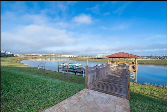 dock area with a water view, a yard, and a gazebo