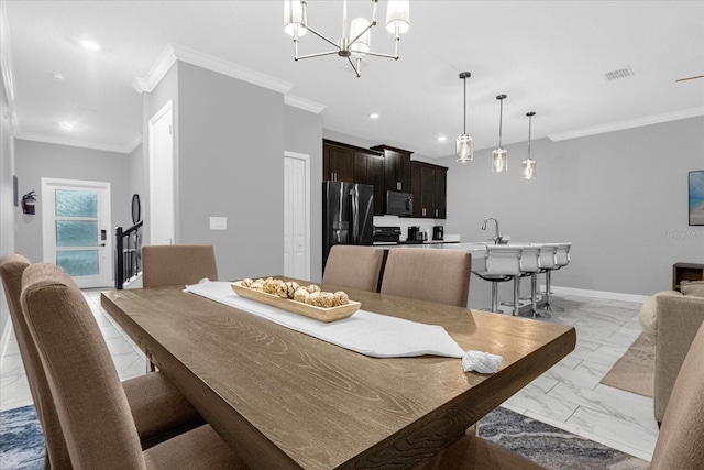 tiled dining room featuring a notable chandelier, crown molding, and sink