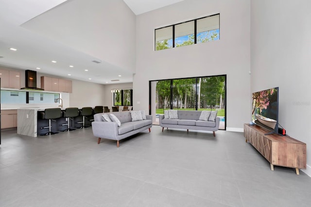 living room featuring a towering ceiling and light tile flooring