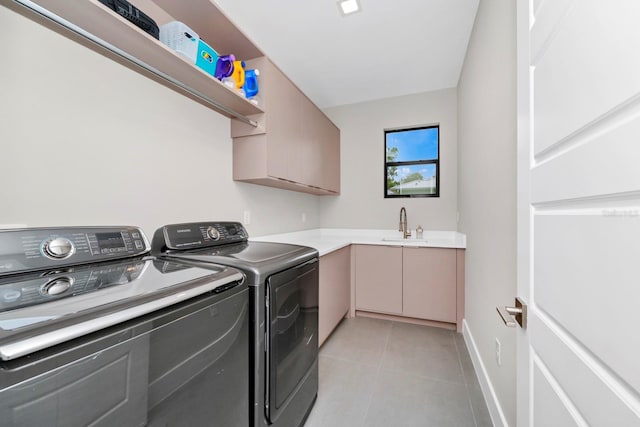 laundry area with washer and dryer, cabinets, sink, and light tile flooring