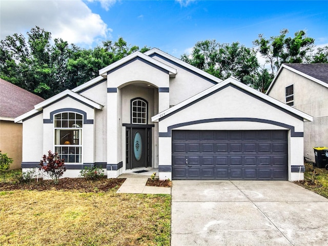 view of front of property featuring stucco siding, concrete driveway, and an attached garage