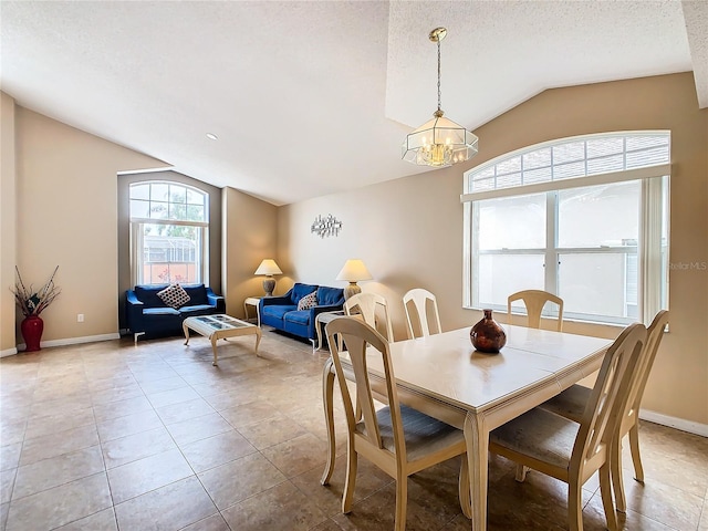 tiled dining area with a notable chandelier, vaulted ceiling, and a textured ceiling