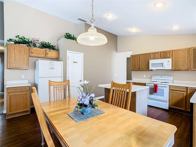 dining space featuring lofted ceiling and dark hardwood / wood-style flooring