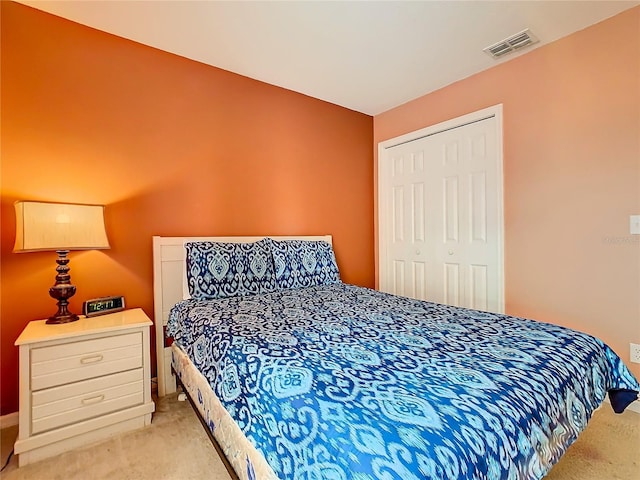 bedroom featuring light colored carpet and a closet