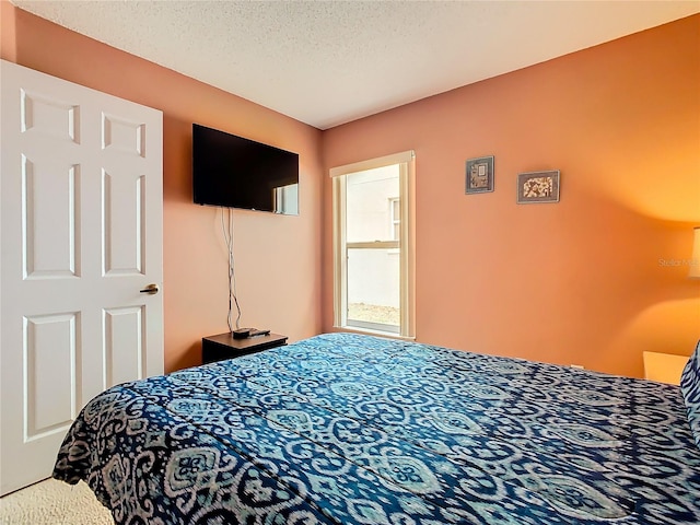 bedroom with a textured ceiling and carpet flooring