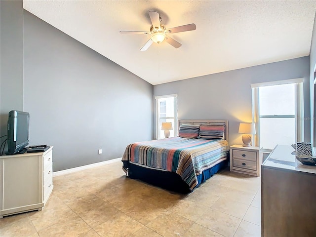 tiled bedroom with a textured ceiling, ceiling fan, and vaulted ceiling