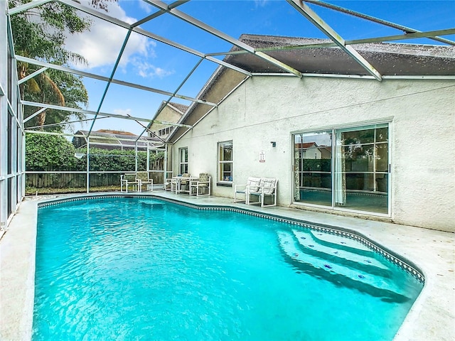 view of swimming pool with a lanai and a patio area