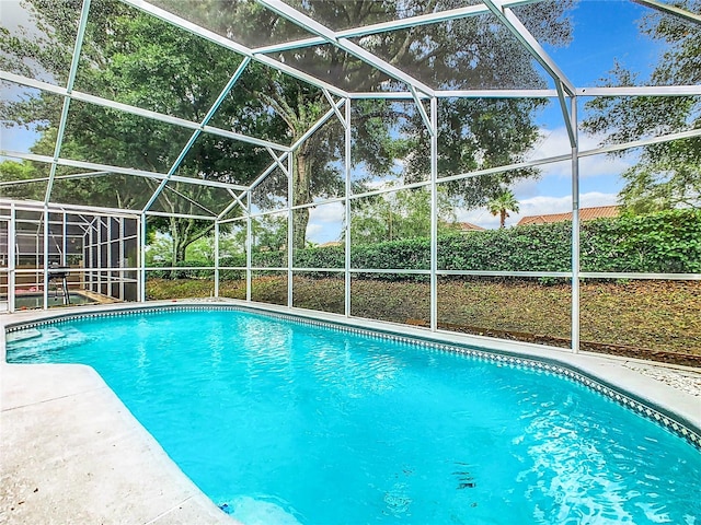 view of swimming pool with a patio and a lanai