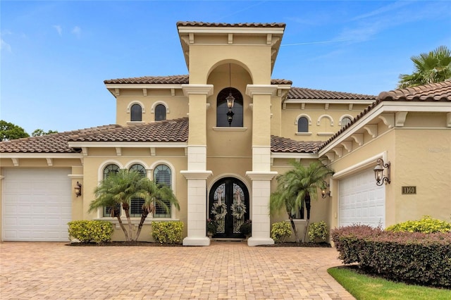 mediterranean / spanish home featuring french doors and a garage