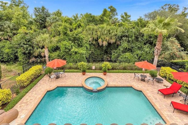 view of swimming pool featuring a patio area and an in ground hot tub