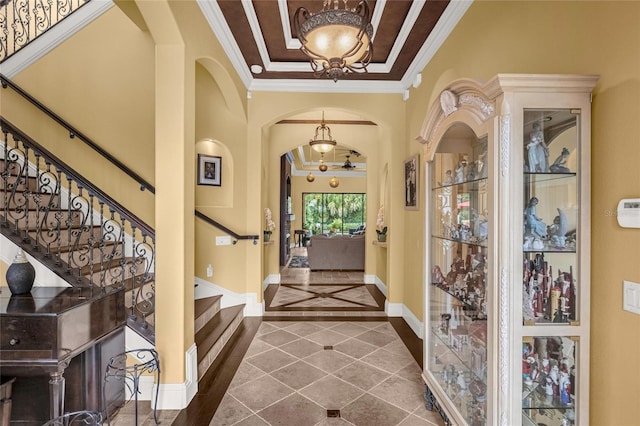 entryway featuring crown molding and a chandelier