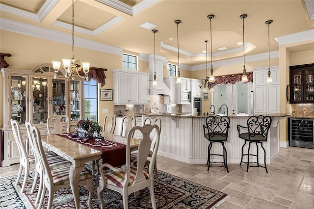 dining room with beam ceiling, beverage cooler, coffered ceiling, a notable chandelier, and crown molding