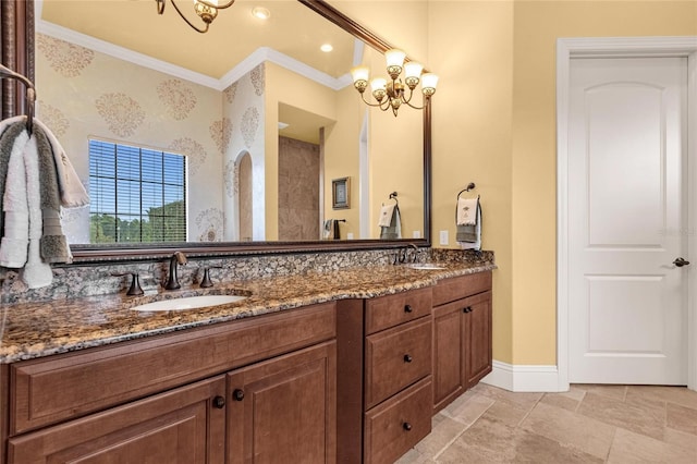 bathroom with a chandelier, vanity, and crown molding