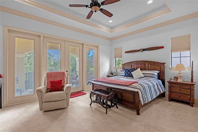 bedroom with ceiling fan, crown molding, a tray ceiling, light colored carpet, and access to outside