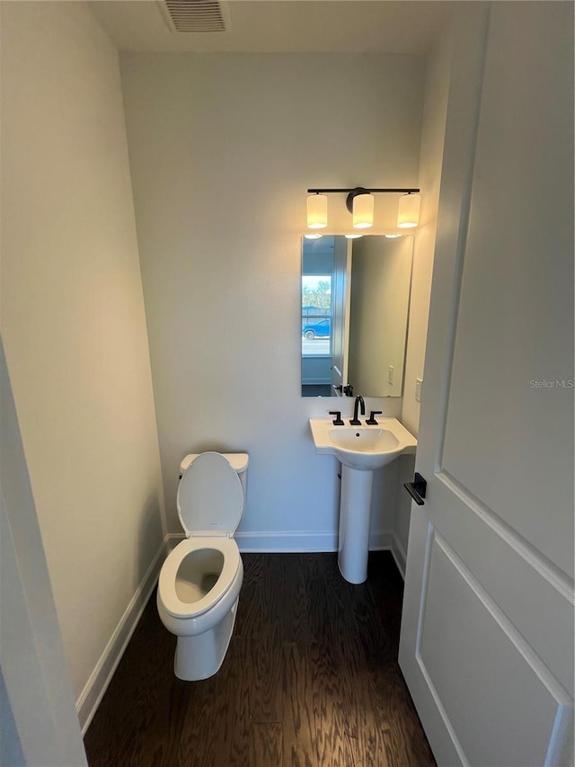 bathroom featuring wood-type flooring and toilet