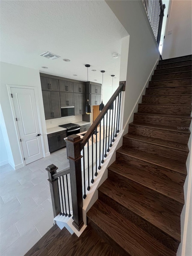 stairs with hardwood / wood-style flooring and a textured ceiling