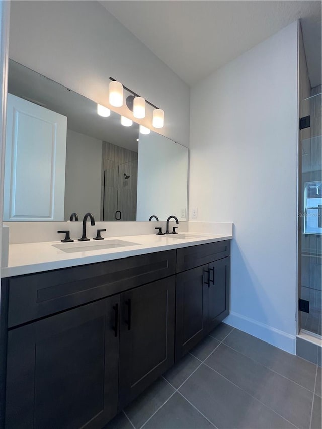 bathroom with tile patterned flooring, vanity, and walk in shower