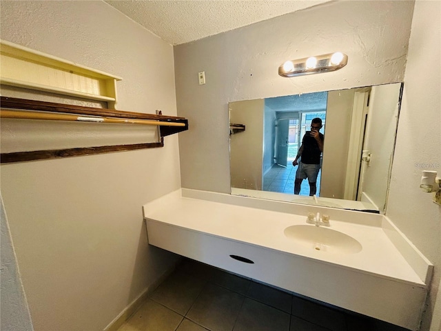 bathroom featuring tile flooring, oversized vanity, and a textured ceiling