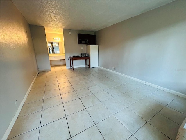 unfurnished living room featuring a textured ceiling and light tile patterned floors