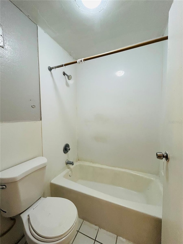 bathroom featuring tile patterned floors, toilet, and tub / shower combination