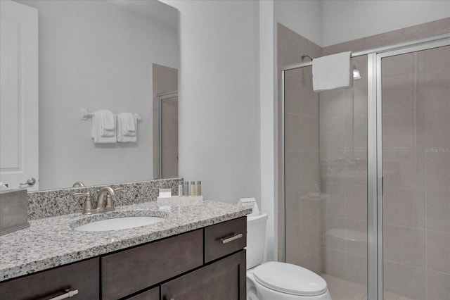 bathroom with walk in shower, vanity, and toilet