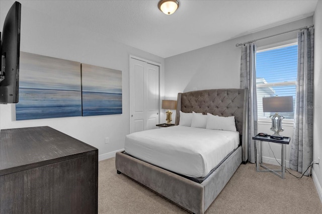 bedroom featuring a closet and light colored carpet