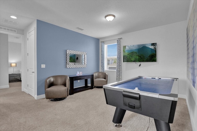 game room featuring light carpet and a textured ceiling