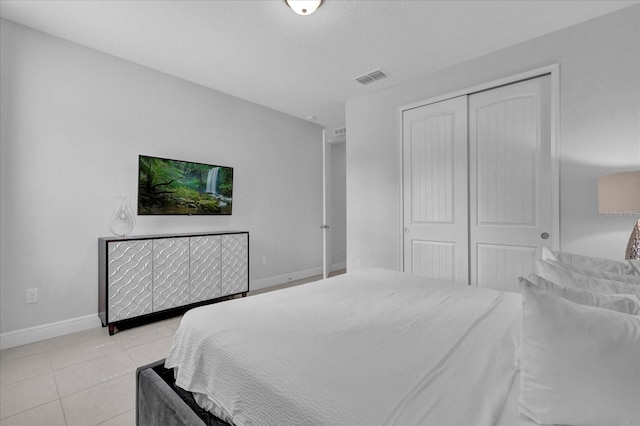 bedroom with a closet and light tile patterned flooring