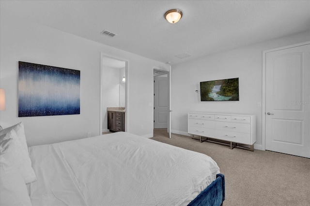 carpeted bedroom featuring ensuite bath