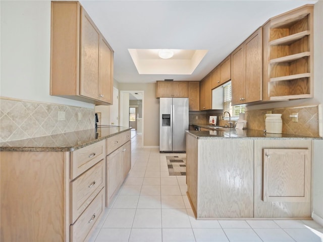 kitchen featuring decorative backsplash, stainless steel fridge, light brown cabinetry, sink, and light tile patterned flooring