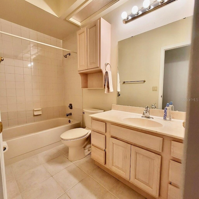 full bathroom with tile patterned flooring, tiled shower / bath combo, toilet, and vanity