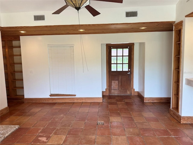 entrance foyer with a towering ceiling, dark tile flooring, and ceiling fan