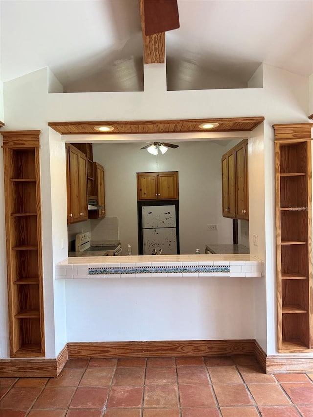 kitchen with tile floors, ceiling fan, white appliances, and lofted ceiling