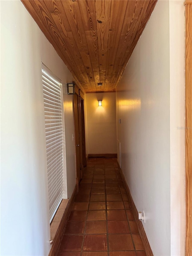 corridor featuring dark tile flooring and wood ceiling