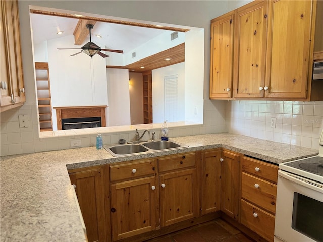 kitchen with dark tile floors, range with electric cooktop, ceiling fan, tasteful backsplash, and sink