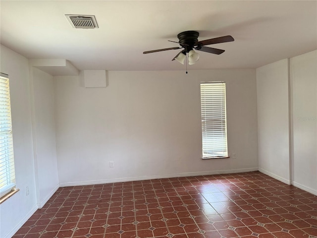 empty room featuring dark tile flooring and ceiling fan