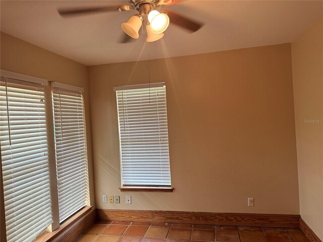 tiled spare room with ceiling fan