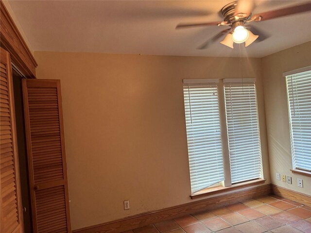 unfurnished room with tile flooring and ceiling fan