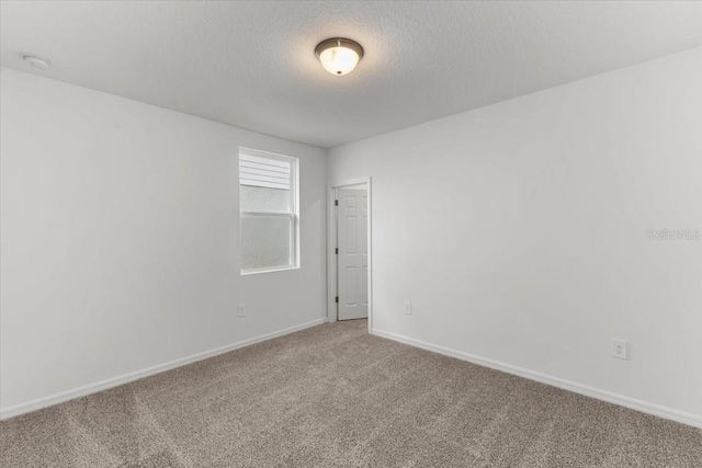 carpeted spare room with a textured ceiling