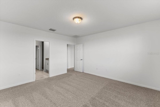 carpeted empty room with a textured ceiling