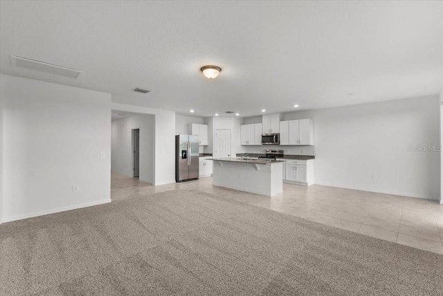 unfurnished living room featuring light carpet and a textured ceiling